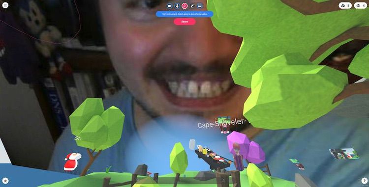 Screenshot of hubs with my face hovering in the sky, as someone's Santa Claus avatar watches my face